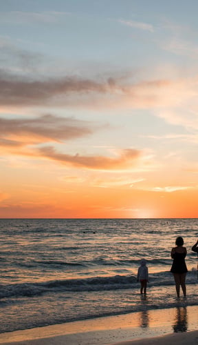 Family silhouetted against a warm Florida sunset on the beach