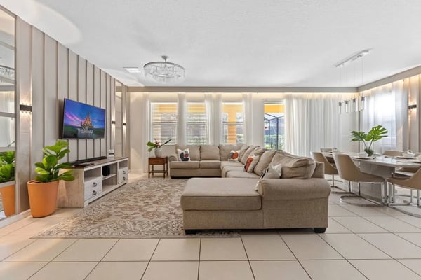 Modern kitchen with white cabinetry, white subway tile backsplash, island with seating, and black appliances